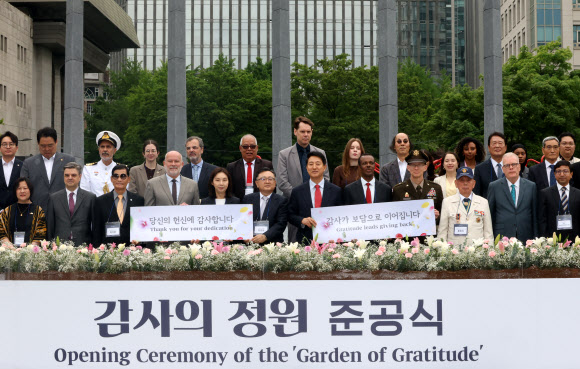 12일 서울 종로구 광화문광장에서 열린 ‘감사의 정원 준공식’에서 국민의힘 오세훈 서울시장 후보와 6.25 참전유공자, 각국 대사들이 기념 촬영하고 있다. 2026.5.12  연합뉴스