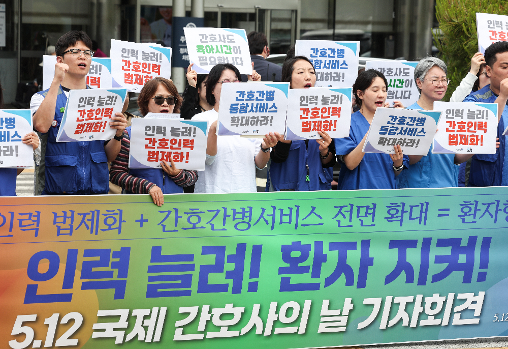 공공운수노조 의료연대본부와 행동하는 간호사회 회원들이 12일 서울 종로구 서울대학교병원 본관 앞에서 열린 ‘인력 늘려! 환자 지켜! 5.12 국제 간호사의 날 기자회견’에서 간호 인력 충원 및 법제화, 간호·간병통합서비스 전면 확대, 교대제 간호사의 육아기 근로시간 단축 사용 등을 촉구하며 구호를 외치고 있다. 2026.5.12 뉴스1