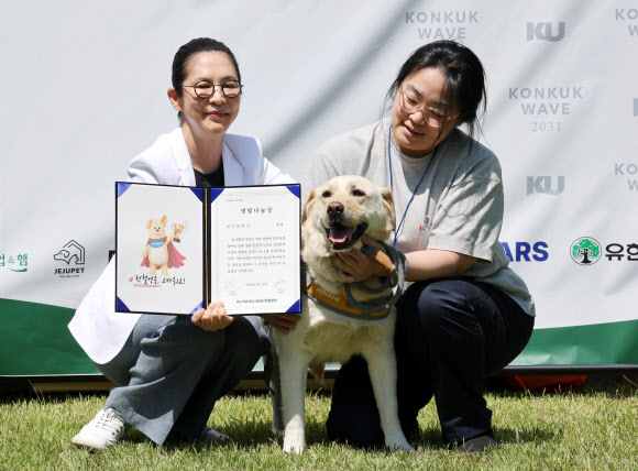 13일 서울 광진구 건국대학교에서 ‘KU아임도그너’ 헌혈센터 개소 5년을 맞아 열린 ‘헌혈 영웅, 고마워요!’ 행사에서 생명나눔상을 수상한 최다헌혈견 ‘복희’가 견주와 기념 촬영을 하고 있다. 2026.5.13 연합뉴스
