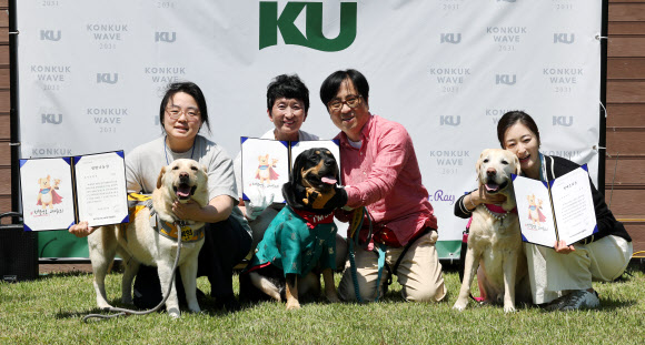 13일 서울 광진구 건국대학교에서 ‘KU아임도그너’ 헌혈센터 개소 5년을 맞아 열린 ‘헌혈 영웅, 고마워요!’ 행사에서 생명나눔상을 수상한 최다헌혈견 ‘복희’(왼쪽부터), 생명수호상을 수상한 응급헌혈견 ‘순돌’, 명예은퇴상을 수상한 헌혈견 ‘트리’가 견주들과 기념 촬영을 하고 있다. 2026.5.13 연합뉴스