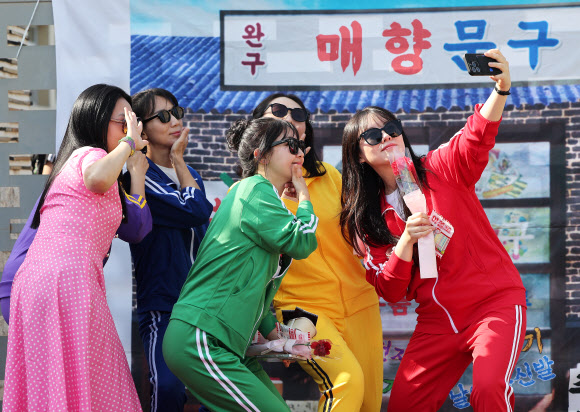 스승의날인 15일 경기도 수원시 팔달구 매향중학교에서 열린 ‘추억의 책가방’ 행사에서 복고풍 의상을 입은 선생님들이 사진을 찍고 있다. 2026.5.15 연합뉴스