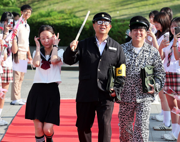스승의날인 15일 경기도 수원시 팔달구 매향중학교에서 열린 ‘추억의 책가방’ 행사에서 교복을 입은 선생님들이 레드카펫을 밟고 있다. 2026.5.15 연합뉴스
