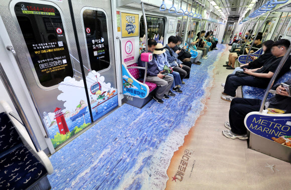 도시철도 전동차 내부를 부산 관광명소로 꾸며 여름 명물로 떠오른 ‘메트로마린’이 19일 부산 도시철도 2호선에서 운행 중이다.  부산교통공사는 이달부터 오는 9월까지 부산도시철도 1호선과 2호선에 테마열차 ‘메트로마린’을 각 1대씩 운행한다. 2026.5.19 연합뉴스