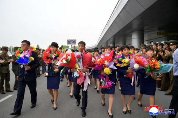 2026년 아시아축구연맹(AFC) 17살미만 여자아시아컵에서 우승한 북한 여자축구팀이 지난 19일 귀국했다고 조선중앙통신이 20일 보도했다. 감독과 선수들이 꽃다발을 안고 평양국제비행장을 빠져나오고 있다. 2026.5.20  평양 조선중앙통신 연합뉴스