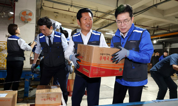 6·3 지방선거 공식 선거운동의 막이 오른 21일 0시 더불어민주당 정원오 서울시장 후보가 정청래 대표, 고민정 의원, 이정헌 의원, 문종철 광진구청장 후보와 함께 서울 광진구 동서울우편집중국을 찾아 택배 업무를 체험하고 있다.  2026.5.21 연합뉴스