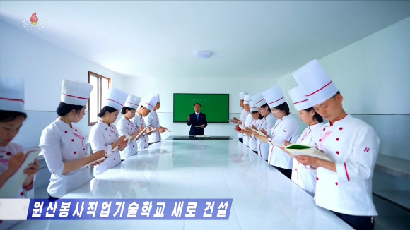 북한 강원도에 대외 봉사원 양성을 위한 원산 봉사직업기술학교가 새로 건설됐다고 조선중앙TV가 25일 보도했다. 조리복과 조리모를 착용한 학생들이 교재를 보며 요리 교육을 받고 있다. 2026.5.26. 조선중앙TV 화면 연합뉴스