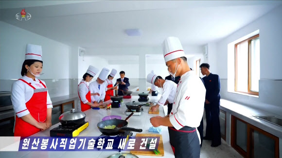 북한 강원도에 대외 봉사원 양성을 위한 원산 봉사직업기술학교가 새로 건설됐다고 조선중앙TV가 25일 보도했다. 조리복과 조리모를 착용한 학생들이 가스레인지와 조리도구가 갖춰진 실습장에서 요리 실습 교육을 받고 있다. 2026.5.26. 조선중앙TV 화면 연합뉴스
