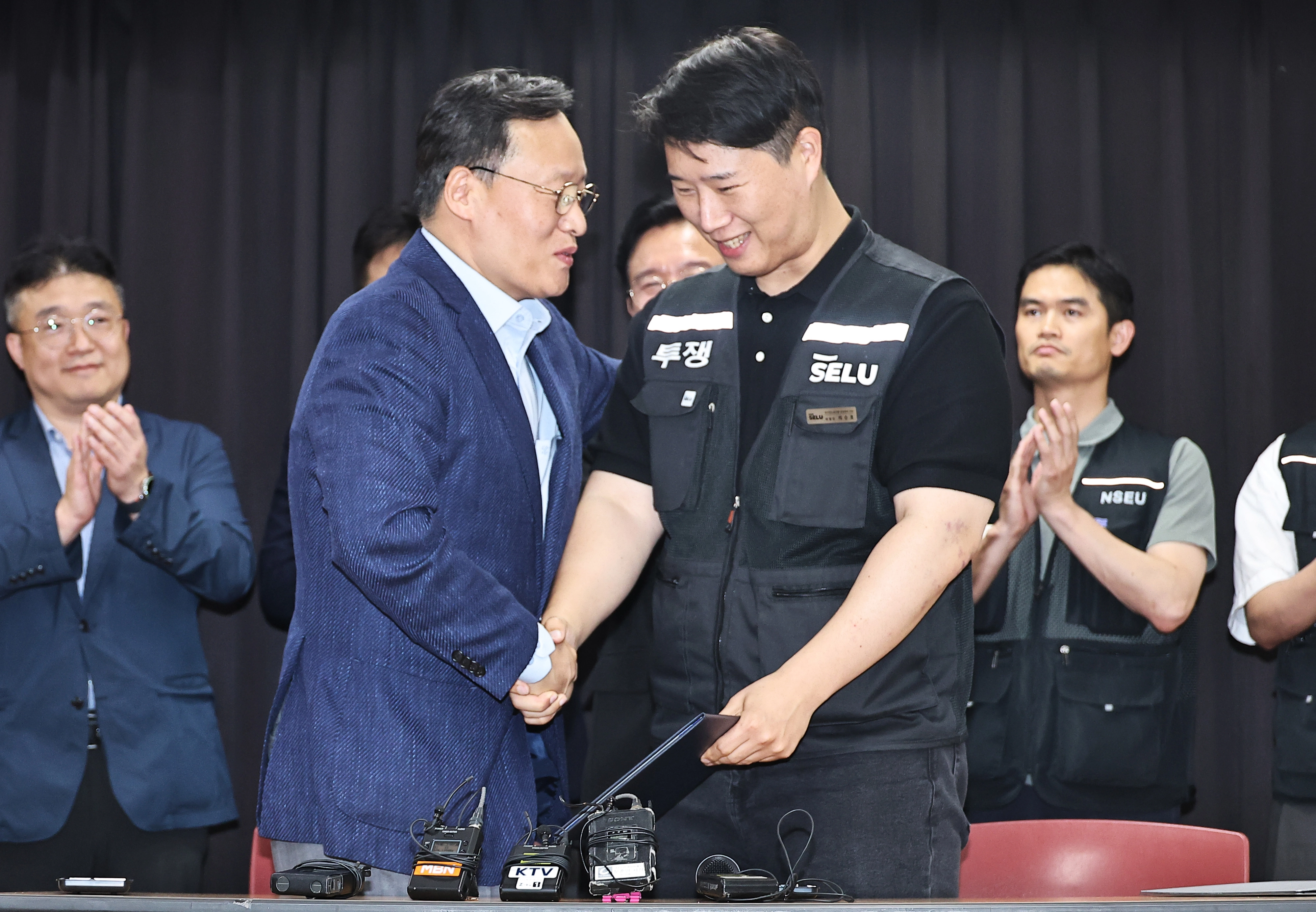 삼성전자 파업 유보  지난 20일 경기도 수원시 장안구 경기고용노동청에서 열린 삼성전자 임금협상을 마친 후 여명구 삼성전자 DS(디바이스솔루션·반도체 사업 담당) 피플팀장과 최승호 삼성그룹 초기업노동조합 삼성전자지부 위원장이 잠정 합의안에 서명한 후 손을 맞잡고 있다. 공동취재