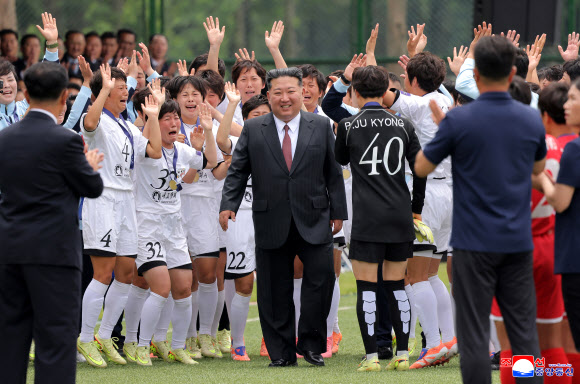 김정은 북한 국무위원장이 지난 1일 노동당 중앙간부학교 창립 80주년 기념행사에서 여자축구 선수들이 두 손을 들어 환호하는 가운데 경기장으로 들어서고 있다. 2026.6.2 평양 조선중앙통신 연합뉴스