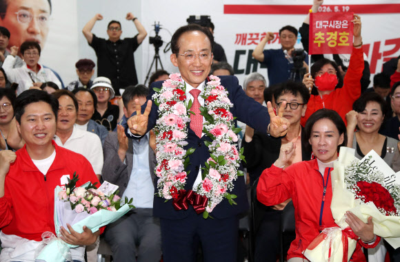 국민의힘 추경호 대구시장 후보가 당선이 유력시되면서 4일 오전 대구 범어네거리 선거사무소에서 축하 꽃다발을 목에 걸고 밝게 웃고 있다. 2026.6.4 연합뉴스