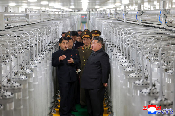 김정은 북한 국무위원장이 지난 3일 최성남 군수공업부 부부장과 함께 새로 가동한 핵물질 생산공장에서 원심분리기 사이로 생산공장을 둘러보고 있다. 김 위원장 뒤로 강경호 핵무기연구소 부소장이 수행하고 있다. 2026.6.4. 평양 조선중앙통신 연합뉴스