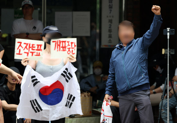 전날 9회 전국동시지방선거 및 국회의원 재·보궐선거 투표용지 부족으로 투표 시간이 오후 10시까지 연장됐던 서울 송파구 잠실7동 제2투표소 앞에서 4일 투표함 반출에 반대하는 시민들이 구호를 외치고 있다. 2026.6.4 연합뉴스