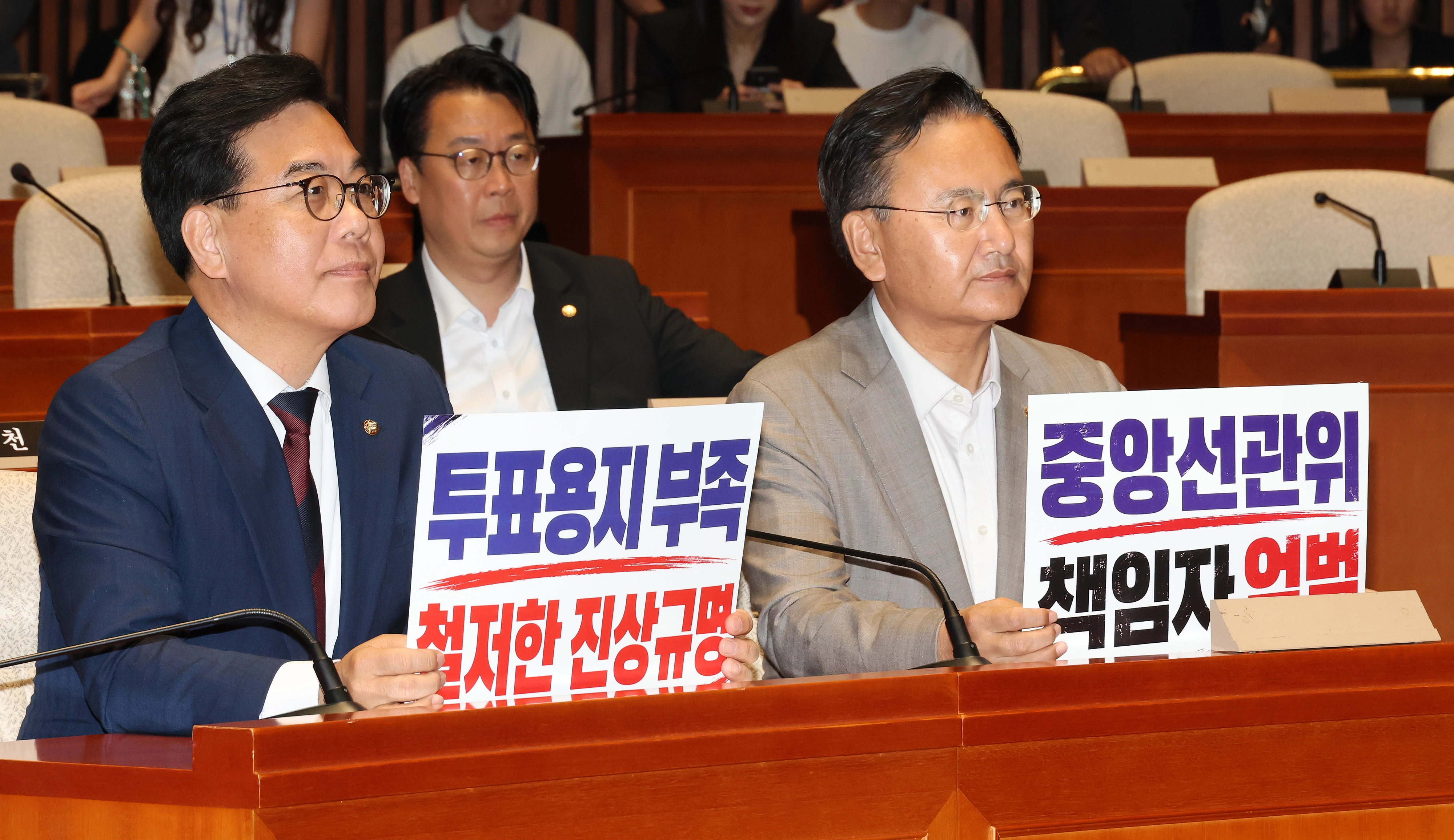 국민의힘 송언석 원내대표와 유상범 원내운영수석부대표가 지난 4일 국회에서 열린 긴급 의원총회에서 투표용지 부족 사태와 관련한 중앙선관위 규탄 손팻말을 들고 있다. 연합뉴스
