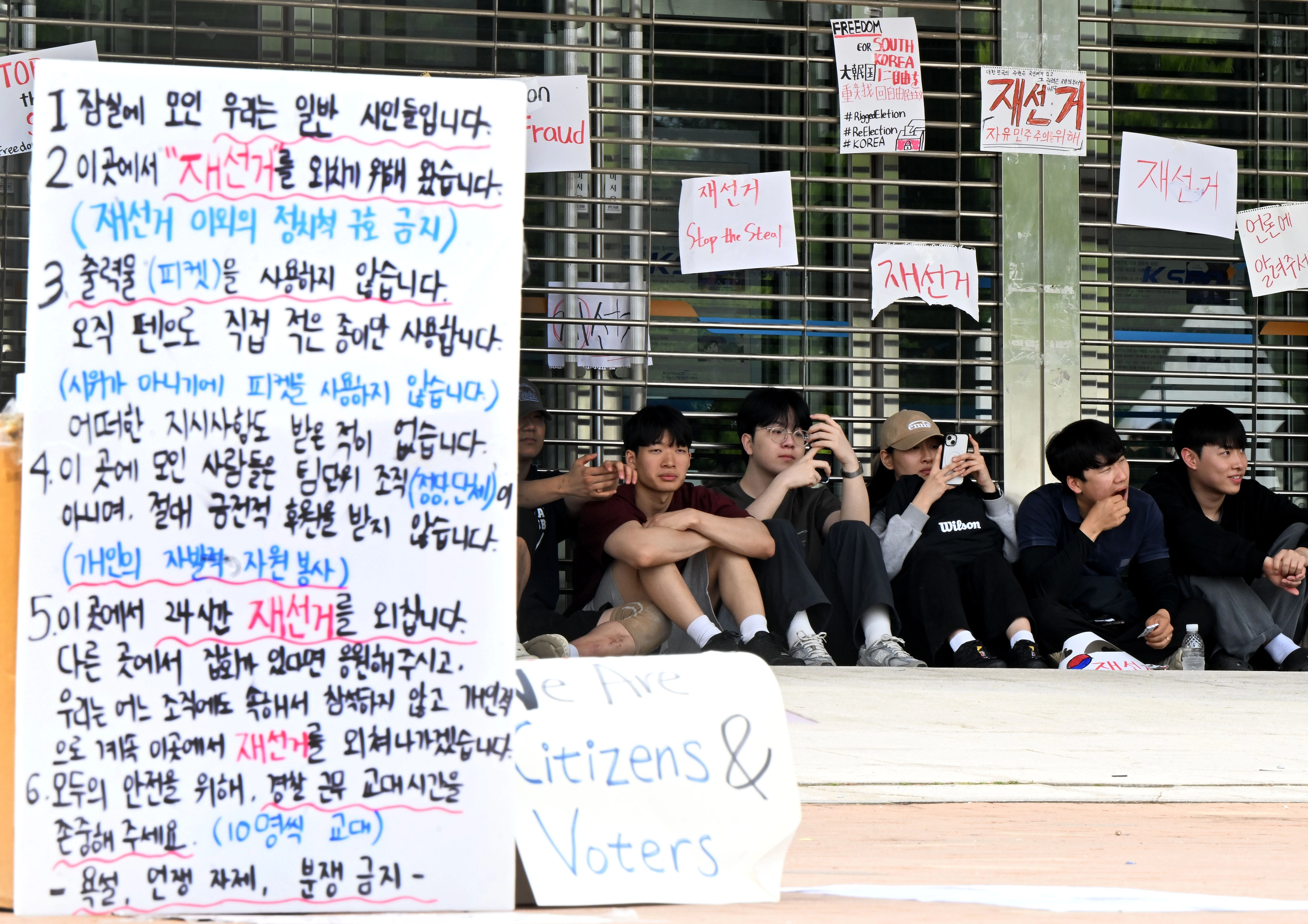 7일 새벽 잠실7동 주민들의 개표소인 서울 송파구 올림픽공원 핸드볼경기장에서 시민들이 경기장 입구에 앉아 있다. 이지훈 기자