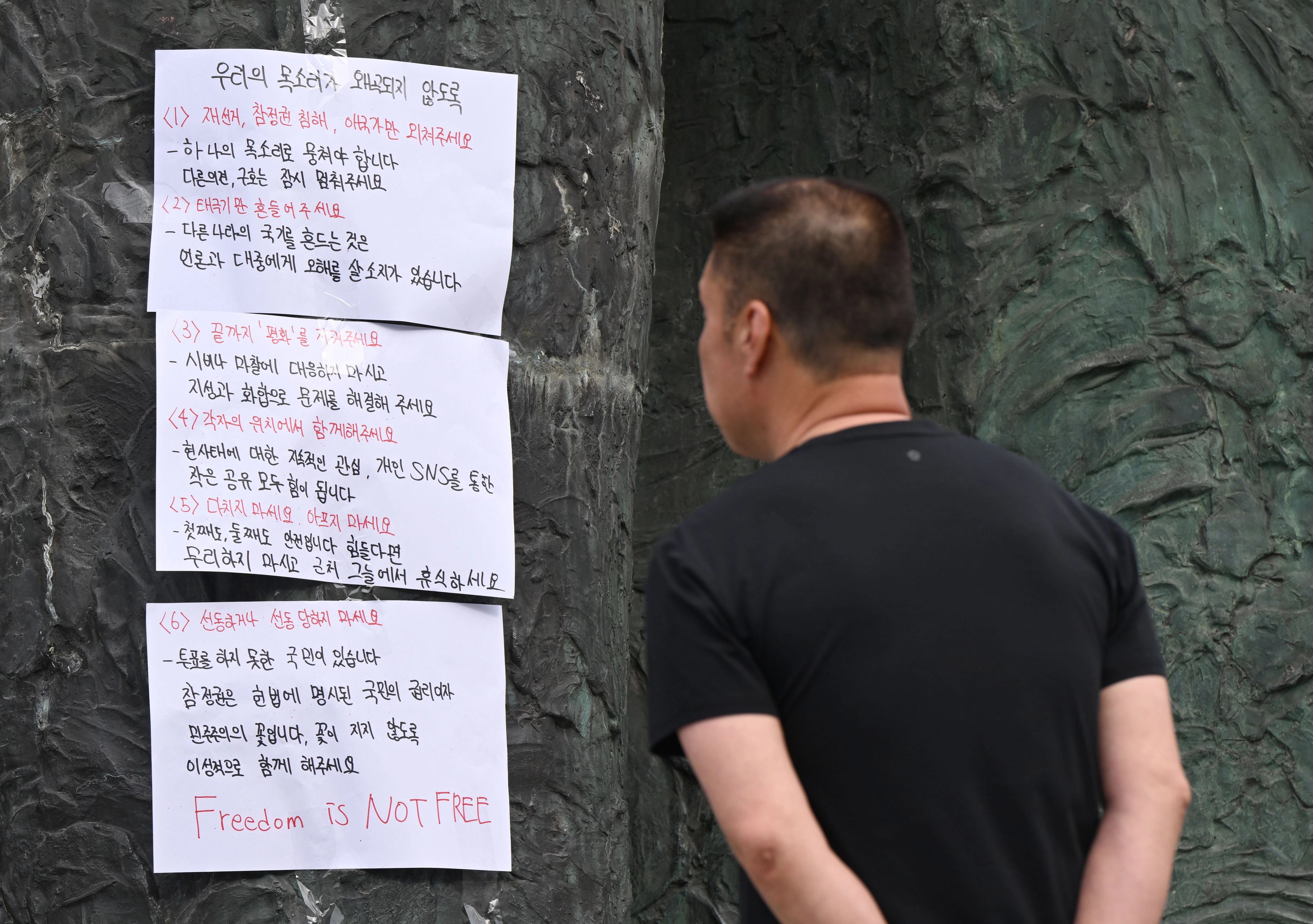7일 서울 송파구 잠실7동 등 투표소의 개표소인 올림픽공원 핸드볼경기장 앞에서 한 시민이 투표용지 부족 사태를 규탄하는 대자보를 읽고 있다.
이지훈 기자