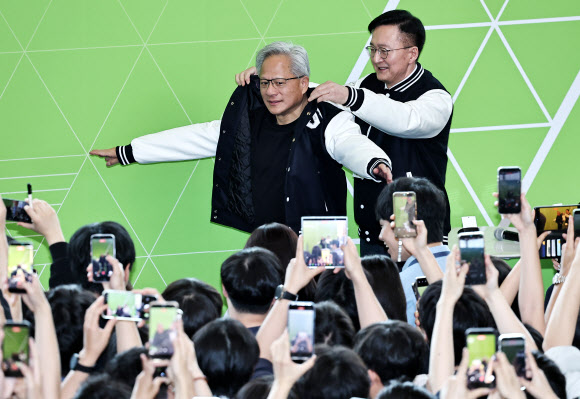 젠슨 황 엔비디아 최고경영자(CEO)가 8일 서울대학교 해동첨단공학관에서 열린 ‘빌드어클로(Build-a-Claw)’ 행사장에서 유홍림 서울대 총장으로부터 학교 점퍼를 선물받고 있다. 2026.6.8  공동취재