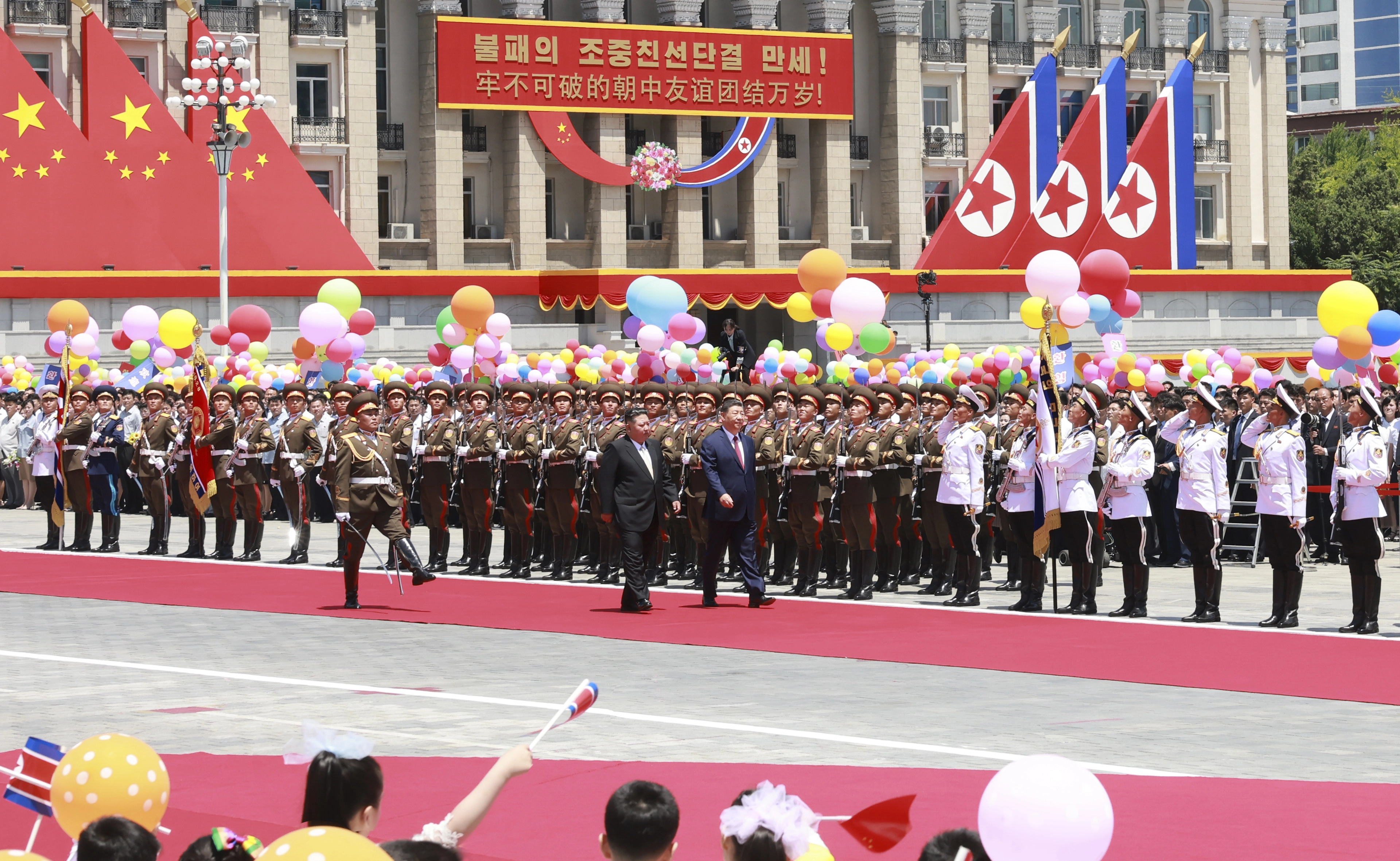 1박 2일 일정으로 북한을 방문한 시진핑 중국 국가주석이 8일 평양 김일성광장에서 열린 환영식에서 김정은 북한 국무위원장과 함께 의장대 사열을 받고 있다. 광장 중심에 위치한 건물에는 ‘불패의 조중(북중) 친선단결 만세’ 환영 문구가 내걸려 있다.
평양 신화 연합뉴스