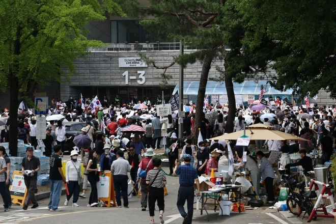 6·3 지방선거 투표용지 부족 사태를 규탄하며 재선거를 요구하는 ‘잠실 개표소 봉쇄 시위’가 계속되고 있는 8일 서울 송파구 올림픽공원 핸드볼경기장 출입구 앞에서 참가자들이 구호를 외치고 있다. 2026.6.8 연합뉴스