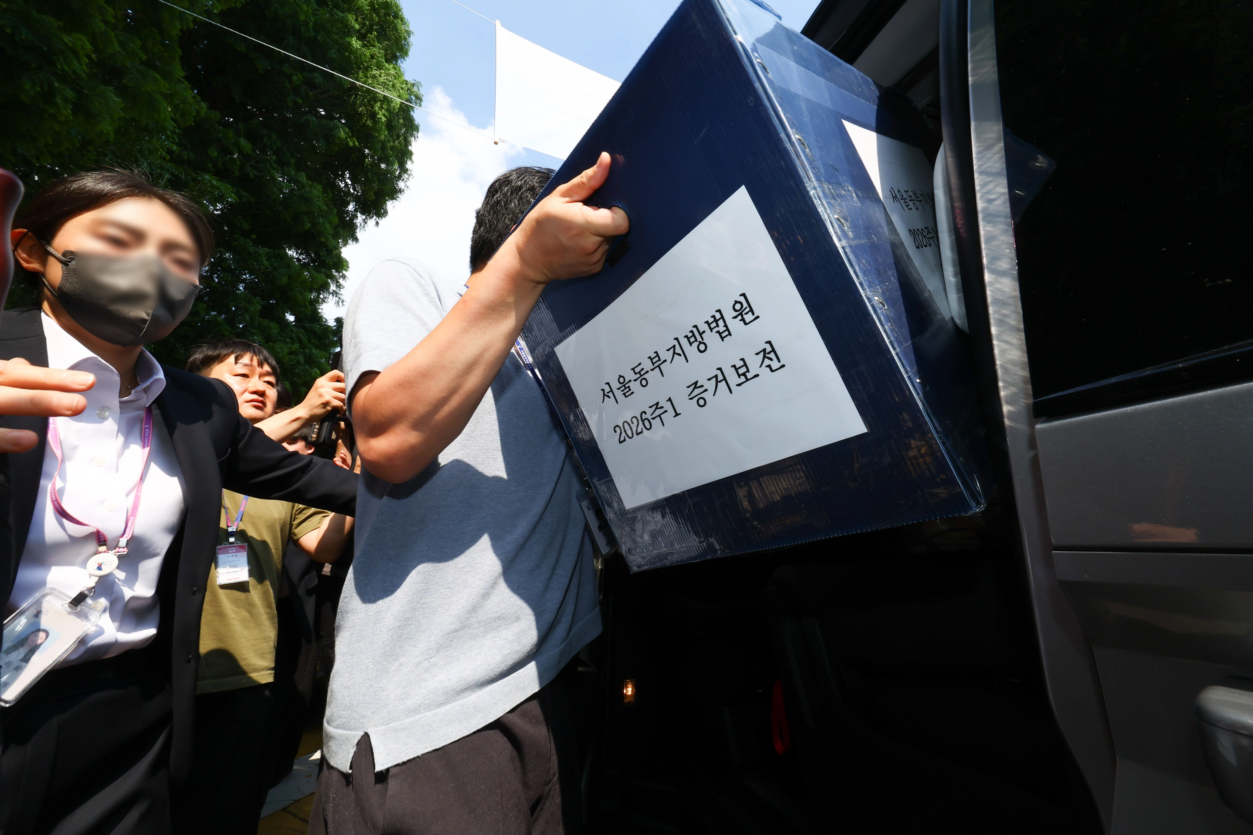 김지연 서울동부지방법원 부장판사와 관계자들이 10일 오후 6·3 지방선거 투표용지 부족 사태가 발생한 잠실7동 제2투표소였던 서울 송파구 우성아파트 노인정의 현장 검증을 마친 뒤 증거물을 들고 현장을 나서고 있다. 2026.6.10 도준석 전문기자