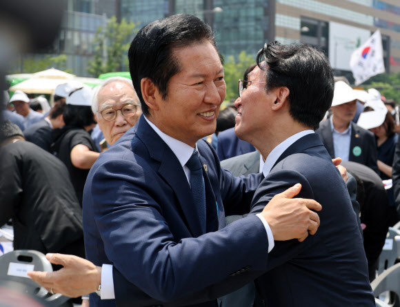 김민석 국무총리와 더불어민주당 정청래 대표가 10일 오전 서울 종로구 광화문광장에서 열린 제100주년  6ㆍ10 만세운동 기념식을 마친 뒤 포옹하고 있다. 2026.6.10 연합뉴스