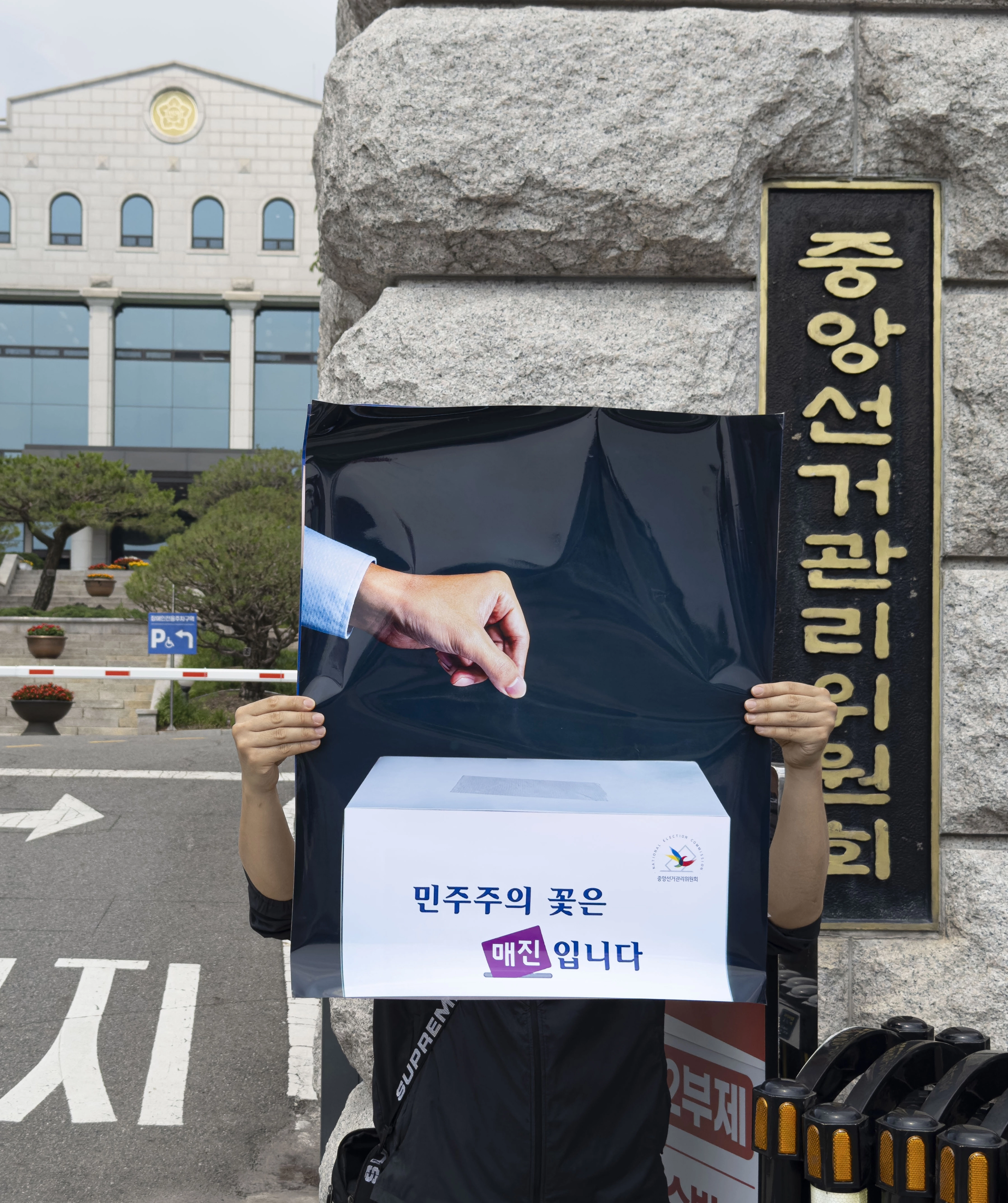 이제석 씨가 펼쳐든 ‘민주주의의 꽃은 매진입니다’ 포스터  ‘이제석 광고연구소’ 대표로 공익광고 전문가인 이제석 씨가 11일 경기도 과천시 중앙선거관리위원회 앞에서 투표용지 부족 사태를 풍자하는 기습 퍼포먼스를 펼치고 있다. 2026.6.11 (이제석 광고연구소 제공) 연합뉴스