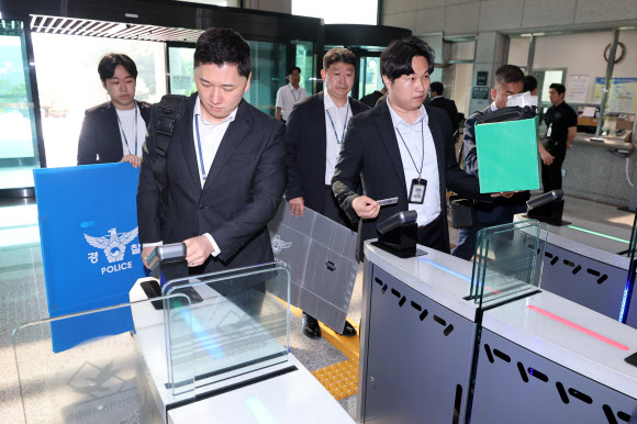 경찰 관계자들이 11일 경기도 과천시 중앙선거관리위원회에서 6ㆍ3 지방선거 투표지 부족사태 관련 압수수색을 위해 청사로 진입하고 있다. 2026.6.11  연합뉴스