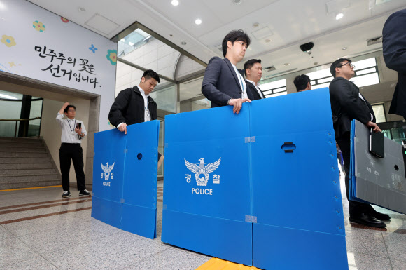 경찰 관계자들이 11일 경기도 과천시 중앙선거관리위원회에서 6ㆍ3 지방선거 투표지 부족사태 관련 압수수색을 위해 청사로 진입하고 있다. 2026.6.11  연합뉴스
