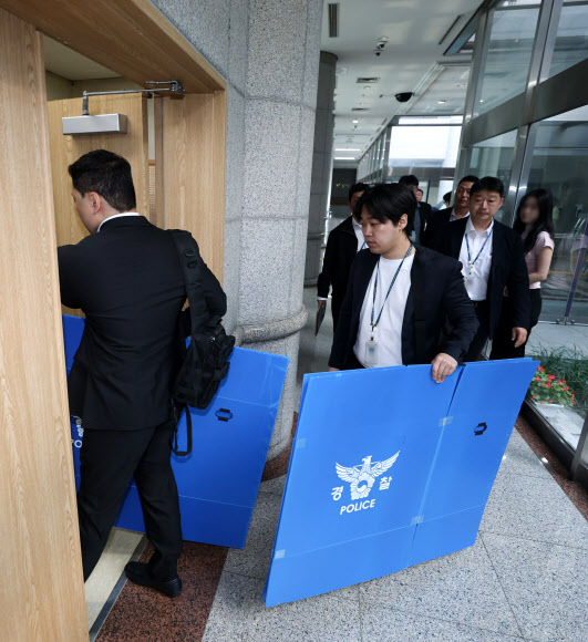 경찰 관계자들이 11일 경기도 과천시 중앙선거관리위원회에서 6ㆍ3 지방선거 투표지 부족사태 관련 압수수색을 위해 청사로 진입하고 있다. 2026.6.11  연합뉴스