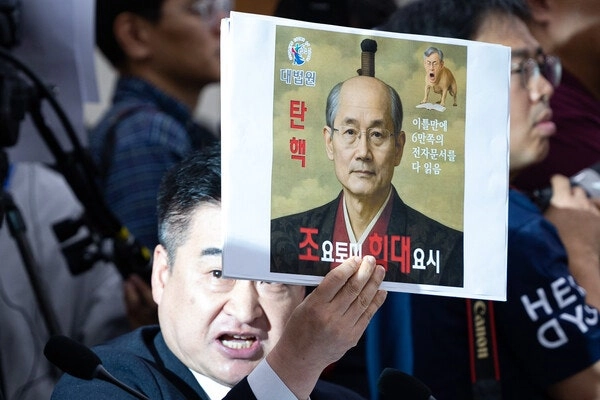 최혁진 무소속 의원이 13일 서울 여의도 국회에서 열린 법제사법위원회의 대법원 등에 대한 국정감사에서 조희대 대법원장에게 질의하며 손팻말을 들어보이고 있다. 국민의힘 제공