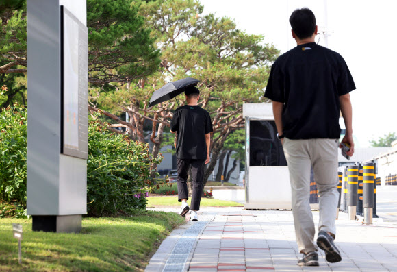 23일 오전 광주 광산구 오선동 삼성전자 그린시티1·2캠퍼스에서 검은 양산을 쓴 직원이 출근하고 있다.  삼성전자의 가전·TV·스마트폰 등을 담당하는 DX(디바이스경험) 부문 직원들은 직원 간 최대 100배에 달하는 성과급 격차가 발생하자 별도 노동조합(동행노조)을 만들어 이 같은 캠페인을 전국 사업장에서 이어가고 있다. 2026.6.23  연합뉴스