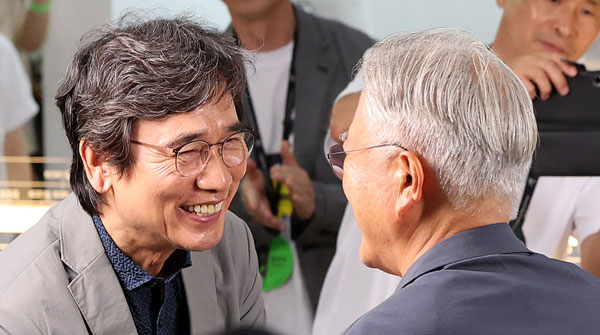 유시민 작가가 25일 서울 강남구 코엑스에서 열린 서울국제도서전 ‘돌베개·평산책방’ 부스를 찾아 문재인 전 대통령(오른쪽)과 악수를 나누고 있다. 2026.6.25 뉴스1