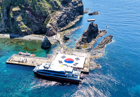 서경덕 성신여대 교수가 시민 70명과 함께 대한민국 독도에 초대형 태극기를 펼쳤다고 29일 밝혔다. 이 태극기는 가로 30m, 세로 20m의 크기로 지난 28일 독도의 동도 선착장 위에 펼쳐졌다. 사진은 독도 상공에서 드론으로 찍은 초대형 태극기 모습. 2026.6.29  성신여자대학교 창의융합학부 서경덕 교수팀 제공