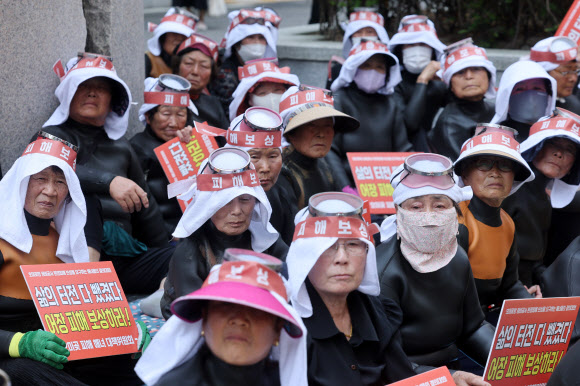 29일 서울 송파구 쌍용건설 본사 앞에서 열린 포항시 남구 호미곶항 정비공사로 인한 해녀피해 보상 촉구 집회에서 참가자들이 발언을 들으며 생각에 잠겨 있다. 2026.6.29  연합뉴스