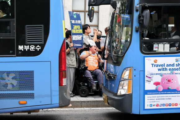 전국장애인차별철폐연대(전장연) 회원이 1일 서울 종로구 혜화동로터리 버스정류장에서 열린 출근길 버스 탑승 시위에서 교통약자이동권보장법 전면 개정을 촉구하고 있다. 2026.7.1 연합뉴스