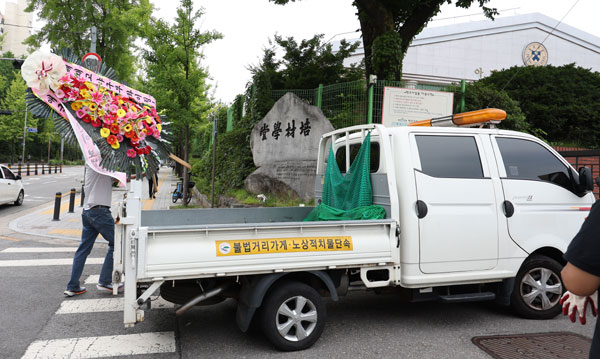 2일 오후 서울 강동구 배재고등학교 앞에 놓여 있던 배재고 야구부 비판 및 응원 화환이 수거되고있다. 배재고 야구부는 지난달 29일 고교야구 대회 도중 상대 팀 광주일고를 향해 ‘스타벅스 가야지’ 응원 구호를 외쳐 논란을 빚었고 대한야구소프트볼협회는 스포츠공정위원회를 개최해 배재고 야구부에 전국대회 출전 정지 6개월 중징계를 내렸다. 배재고 앞에는 논란과 관련된 야구부 비판 및 응원 화환이 다수 놓여 있었으나 이날 오후 도로법 제74조에 근거, 강동구청에 의해 수거 됐다. 2026.07.02. 뉴시스