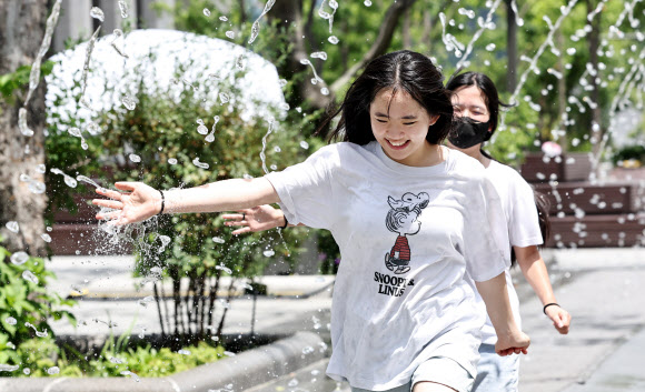 본격적인 더위가 시작한다는 절기상 소서(小暑)인 7일 서울 종로구 광화문광장에서 학생들이 분수대를 지나며 더위를 식히고 있다. 2026.7.7 연합뉴스
