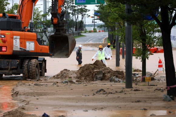 폭우가 내린 9일 세종시 한별동 BRT 교차로 부근 도로가 공사장에서 흘러내린 토사에 덮여 침수되자 작업자들이 복구작업을 벌이고 있다. 2026.7.9 연합뉴스