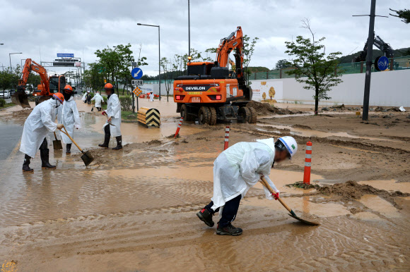 폭우가 내린 9일 세종시 한별동 BRT 교차로 부근 도로가 공사장에서 흘러내린 토사에 덮여 침수되자 작업자들이 복구작업을 벌이고 있다. 2026.7.9 연합뉴스