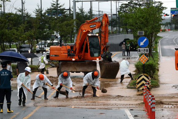 폭우가 내린 9일 세종시 한별동 BRT 교차로 부근 도로가 공사장에서 흘러내린 토사에 덮여 침수되자 작업자들이 복구작업을 벌이고 있다. 2026.7.9 연합뉴스