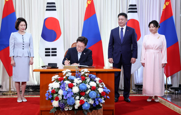 몽골을 국빈 방문한 이재명 대통령이 9일(현지시간) 울란바타르 정부청사에서 오흐나 후렐수흐 대통령이 지켜보는 가운데 방명록을 작성하고 있다. 2026.7.9 연합뉴스