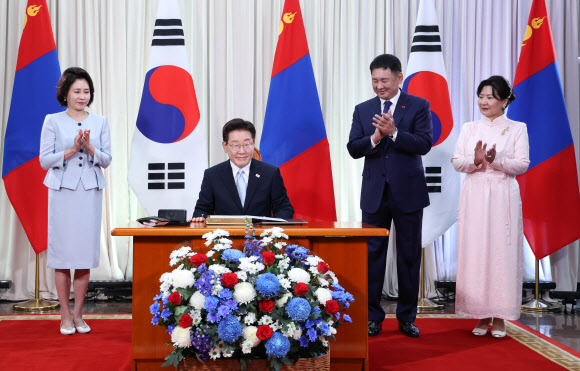 몽골을 국빈 방문한 이재명 대통령이 9일(현지시간) 울란바타르 정부청사에서 오흐나 후렐수흐 대통령이 지켜보는 가운데 방명록을 작성하고 있다. 2026.7.9 연합뉴스