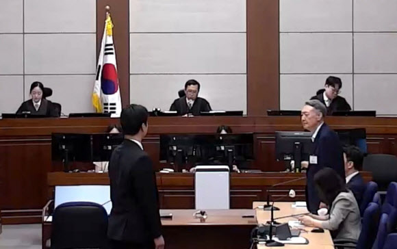 정치 브로커 명태균씨로부터 여론조사를 무상으로 받은 혐의로 기소된 윤석열 전 대통령이 13일 서초구 서울중앙지방법원에서 열린 1심 선고공판에서 선고 내용을 듣고 있다.  서울중앙지법 형사합의33부(이진관 부장판사)는 이날 정치자금법 위반 혐의로 재판에 넘겨진 윤 전 대통령에게 징역 2년에 추징금 1천396만여원을 선고했다. 2026.7.13  서울중앙지법 제공