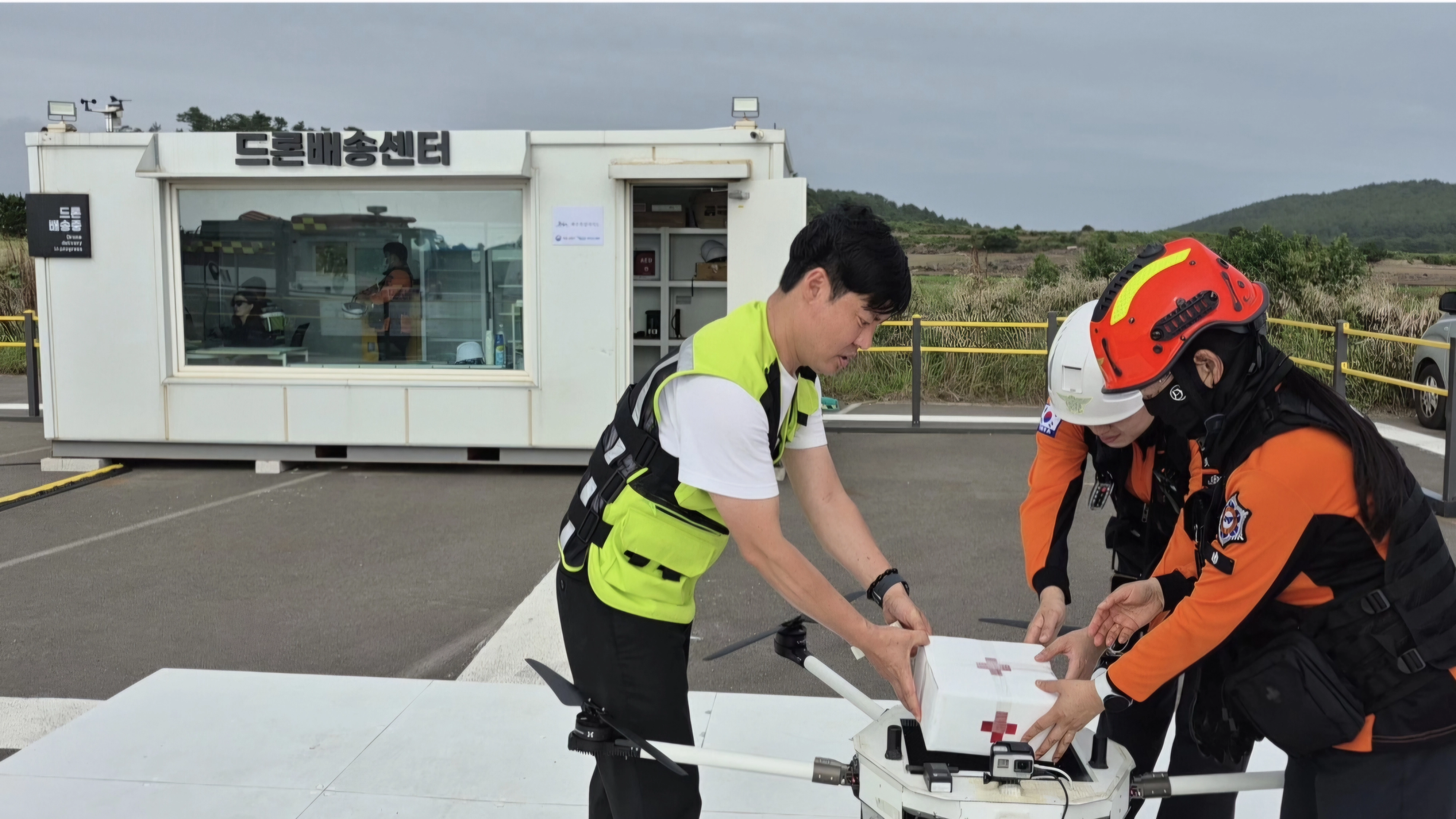 제주도 드론조종 전문관과 소방대원 등 합동대응팀이 13일 서귀포시 대정읍 상모리 드론배송센터 이륙장에서 응급환자에게 배송할 의약품을 싣고 있는 모습. 제주도 제공
