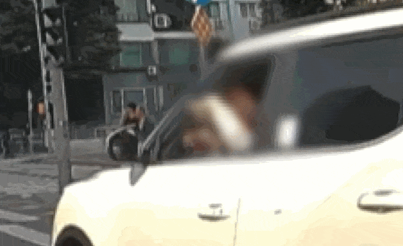 한 여성이 도로에서 운전 중 창밖으로 머리를 내밀고 머리카락을 자르는 모습이 포착돼 논란이다. JTBC 사건반장 캡처