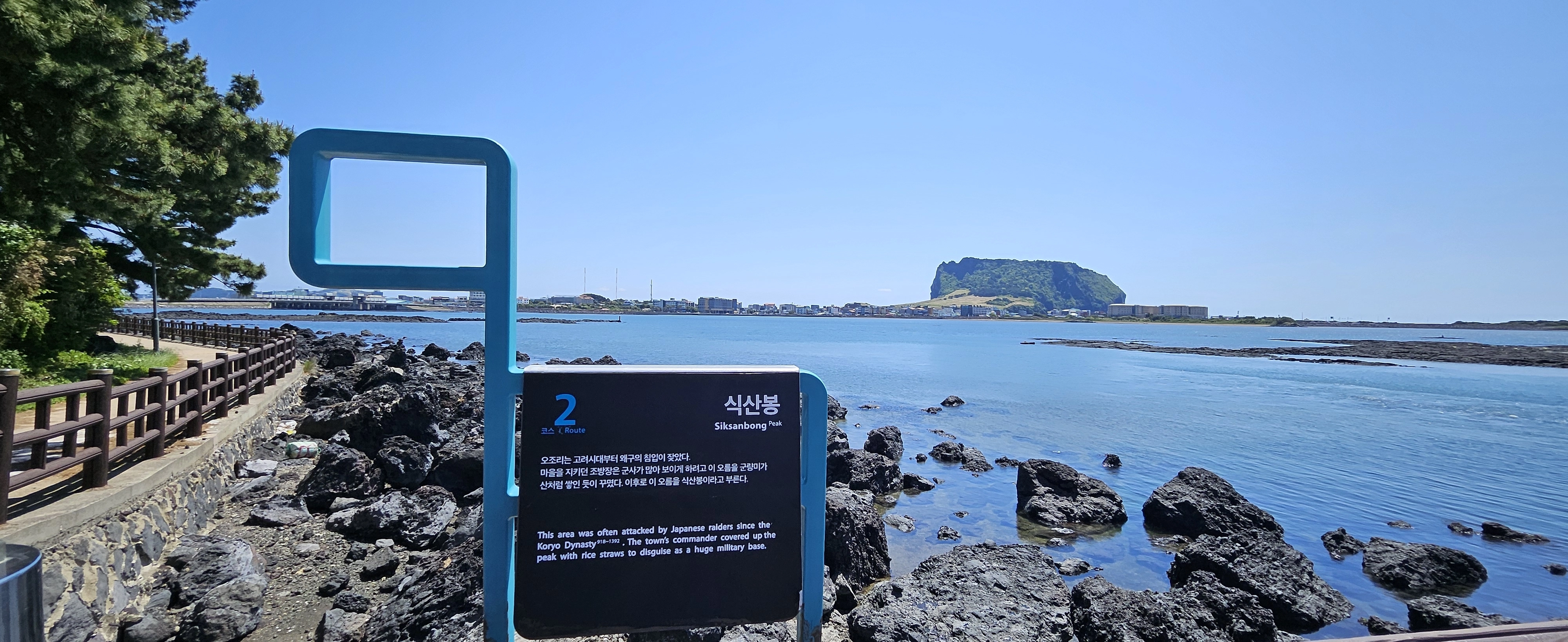 올레길 표시 간세다리에 소개된 식산봉 너머로 성산일출봉이 눈에 선하다.