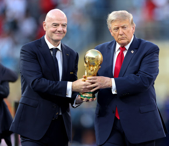 도널드 트럼프(오른쪽) 미국 대통령과 지아니 인판티노 FIFA 회장이 19일(현지시간) 미국 뉴욕 뉴저지 스타디움에서 열린 2026 북중미 월드컵 결승전에서 스페인이 아르헨티나를 꺾고 우승하자 우승 트로피를 스페인 선수들에게 수여하기 위해 들고 있다. AFP 연합뉴스