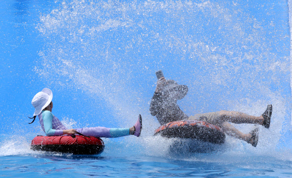 무더위가 이어진 21일 부산 사상구 삼락생태공원 어린이 물놀이장에서 이용객들이 튜브 물썰매를 즐기며 시원한 한낮을 보내고 있다. 2026.7.21 연합뉴스
