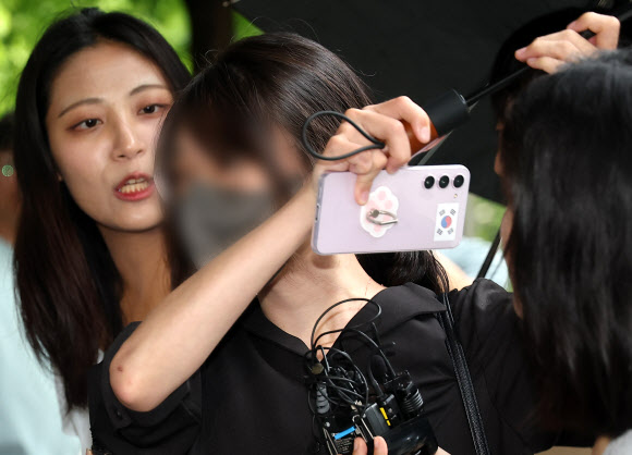 6·3 지방선거 개표소로 사용된 올림픽공원 핸드볼경기장 문 앞에서 체육단체 직원들의 장내 사무실 진입을 막아 업무 방해 혐의를 받는 30대 여성이 21일 구속 전 피의자 심문(영장실질심사)를 위해 서울 송파구 서울동부지방법원으로 출석하고 있다. 강성 보수 커뮤니티에서는 개표소 진입을 홀로 막은 이 여성을 두고 ‘올림픽공원 잔다르크’의 줄임말인 ‘올다르크’라 부르며 추앙하는 움직임이 일었다. 2026.7.21. 연합뉴스