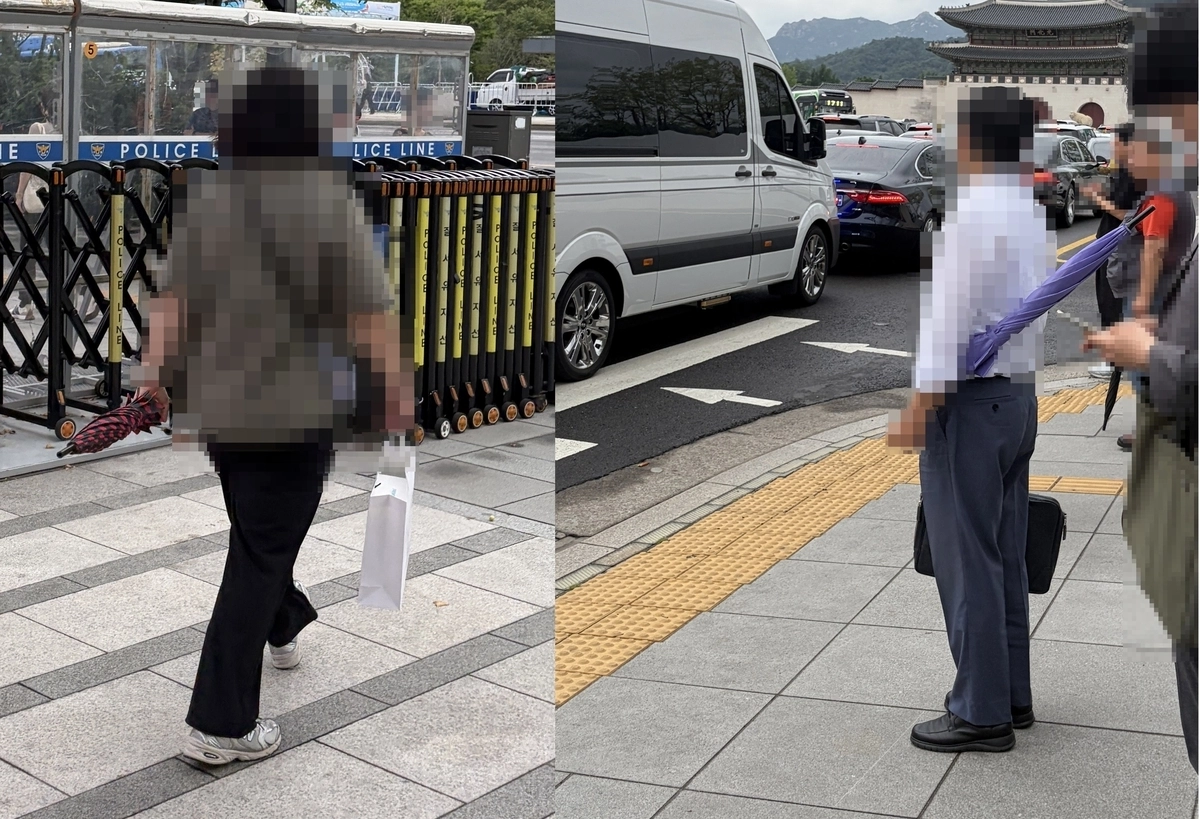 우산을 가로로 들고 다니는 행인들 모습. 연합뉴스