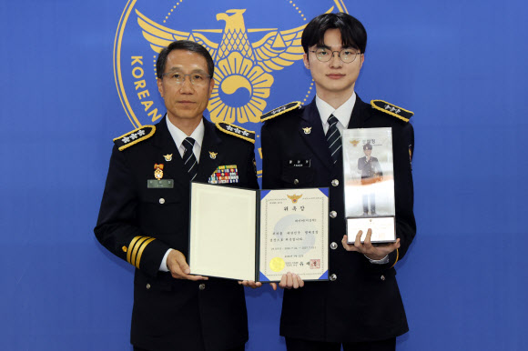 프로게이머 ‘페이커’ 이상혁이 22일 서울 서대문구 경찰청에서 명예경찰 및 사이버도박 예방 홍보대사로 위촉된 뒤 위촉장과 피규어를 들고 유재성 경찰청장 직무대행과 기념 촬영하고 있다. 2026.7.22 연합뉴스